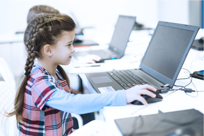 Dziecko korzystające z komputera szkolnego