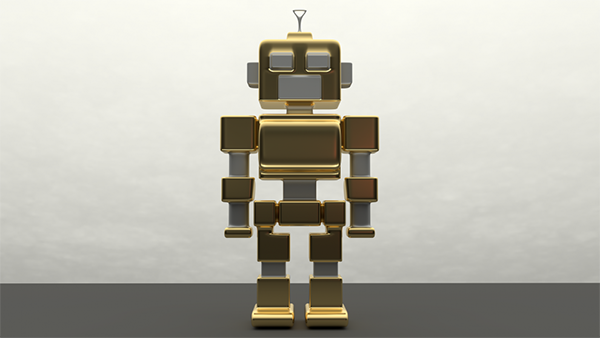 Figurka małego, złoto-srebrnego, robot z antenką na głowie, stojący na szarym blacie na tle białej ściany