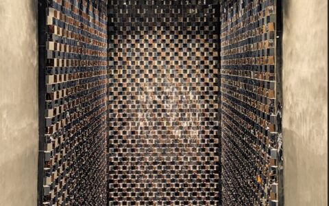 dziwna, niepokojąca ściana - zaułek wąskiego korytarza pokryty metalicznymi kwadracikami