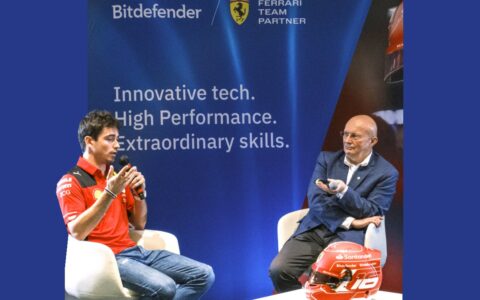 dwóch mężczyzn siedzących na tle baneru z naisami: Bitdefender, Ferrari Team Partner